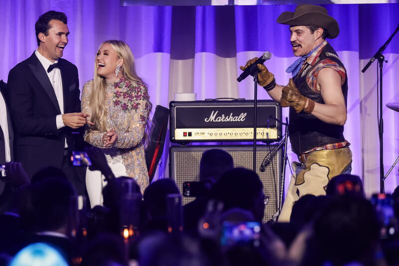 Charlie Kirk (L) and and his wife Erika Lane Frantzve (C) watch as The Village People perform on stage during the Turning Point USA Inaugural-Eve Ball at the Salamander Hotel on January 19, 2025 in Washington, DC.