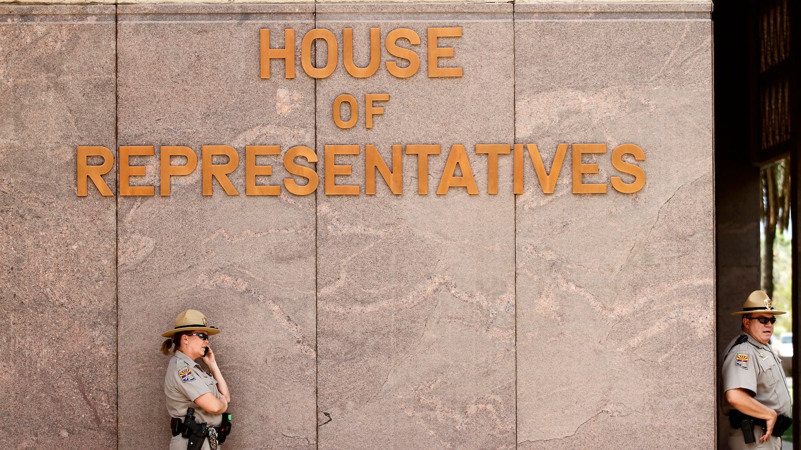 Department of Public Safety Police officers stand guard outside the House of Representatives at the Arizona State Capitol
