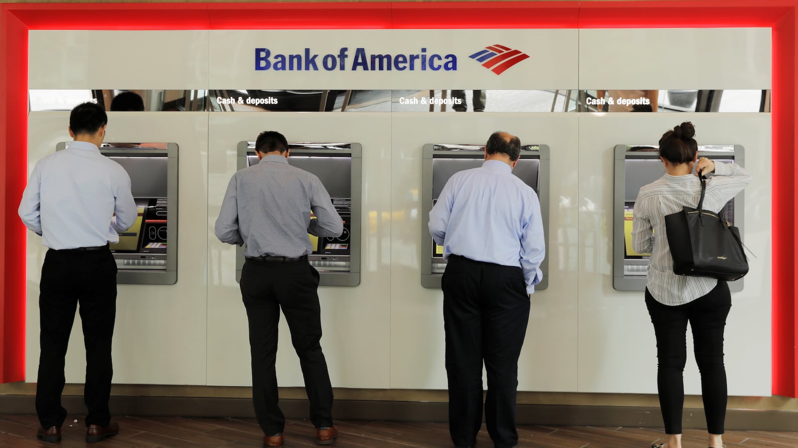 A picture of people withdrawing money from Bank of America ATMs. Bank of America has been ordered to pay $250 million in penalties and restitution from the Consumer Financial Protection Bureau over wrongful fees, among other consumer harms.