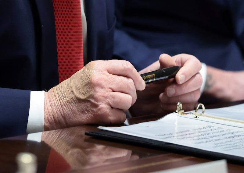 U.S. President Donald Trump holds a Sharpie pen that was custom-made for the White House, during a cabinet meeting at the White House in Washington, D.C., U.S., March 26, 2026. REUTERS/Evelyn Hockstein