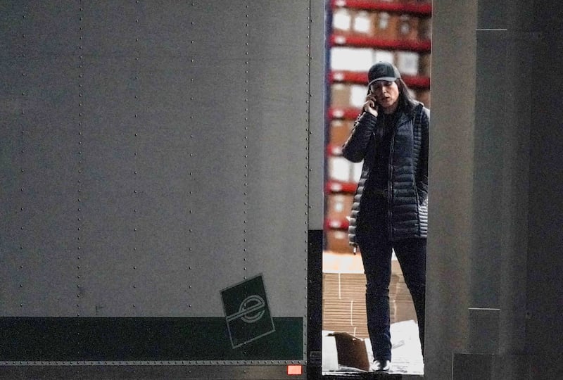 United States Director of National Intelligence Tulsi Gabbard speaks on the phone while standing at the edge of a truck loading bay after the Federal Bureau of Investigation (FBI) executed a search warrant for the Fulton County Election Hub and Operation Center in relation to the 2020 election, according to a law enforcement official familiar with the matter, in Union City, Georgia, U.S., January 28, 2026.  REUTERS/Elijah Nouvelage.  REFILE - CORRECTING INFORMATION FROM "INSIDE A VEHICLE LOADED WITH BOXES OUTSIDE THE FULTON COUNTY ELECTION HUB AND OPERATION CENTER" TO "AT THE EDGE OF A TRUCK LOADING BAY".