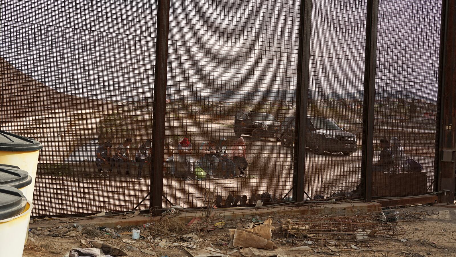 Migrants wait to be picked up by United States Border Patrol as Texas State Troopers stand guard on the U.S-Mexico border in El Paso, Texas.