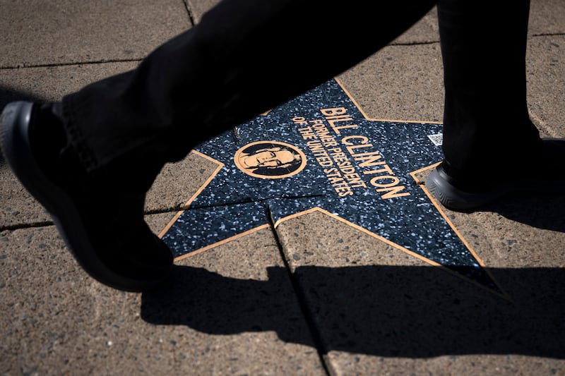 A person walks over a star with the name of former US President Clinton along the "Jeffrey Epstein Walk of Shame," which features prominent names that appear in the Epstein files, near the White House on March 1, 2026, in Washington, DC. Former US president Bill Clinton denied wrongdoing on February 27 to a congressional panel probing his links to Jeffrey Epstein, before calling on others to testify as Democrats seek to shift focus onto Donald Trump's ties to the sex offender. Clinton features prominently in the Epstein files but insists that he broke ties well before the disgraced billionaire's 2008 conviction for sex offenses.