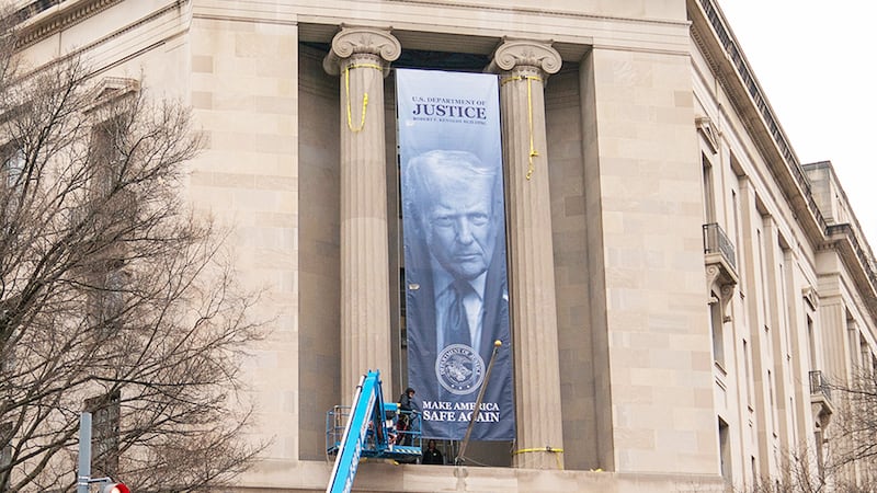 A banner showing President Donald Trump is hung from the Department of Justice, Thursday, Feb. 19, 2026, in Washington, D.C.