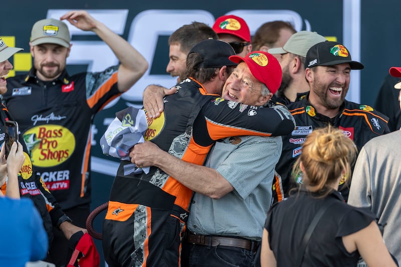 NASCAR Cup Series driver Chase Briscoe (19) hugs Johnny Morris the owner of Bass Pro Shops  in Victory Lane after winning the YellaWood 500 at Talladega Superspeedway in October 2025.