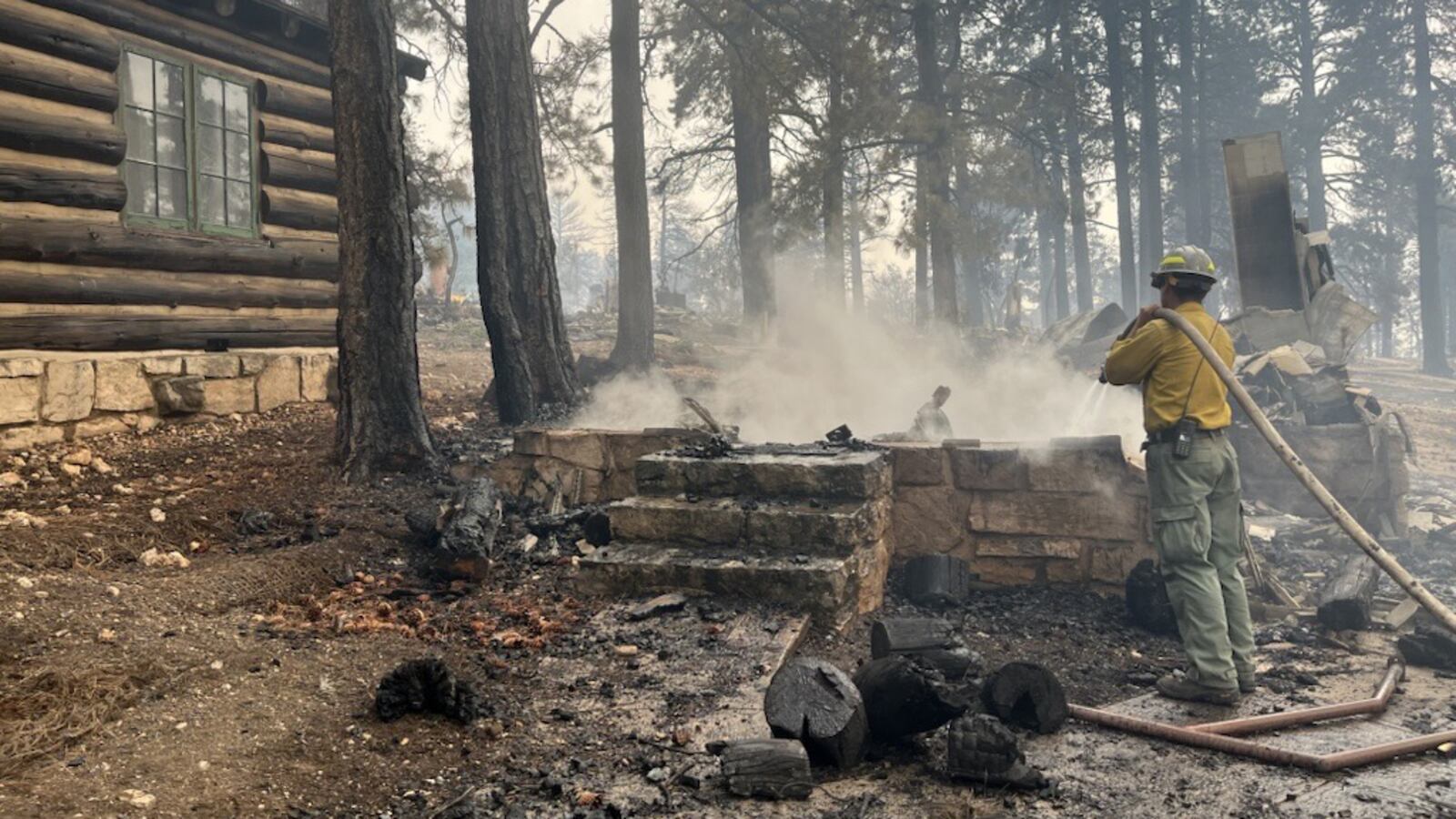 GRAND CANYON NATIONAL PARK - JULY 13: (EDITOR’S NOTE: This Handout image was provided by a third-party organization and may not adhere to Getty Images’ editorial policy.) (Photo by Grand Canyon National Park via Getty Images) In this handout image provided by Grand Canyon National Park, A firefighter stands near smoldering debris and active flames amid the charred remains of burned structures near the Grand Canyon Lodge at Grand Canyon National Park on July 13, 2025. The fire is located on the North Rim of the park and is estimated at 1,500 acres. Due to increased fire activity, mandatory evacuation orders were issued earlier today for North Rim residents. (Photo by Grand Canyon National Park via Getty Images)