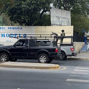 A man with a machine gun in the back of a truck