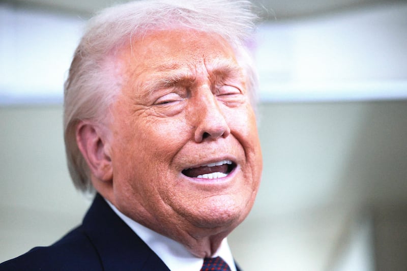 U.S. President Donald Trump speaks to reporters on board Air Force One