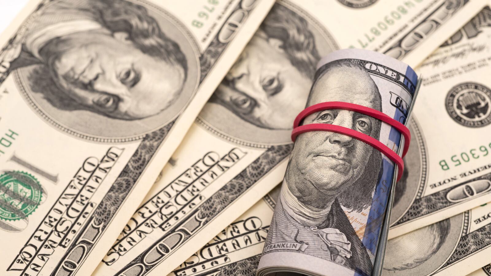 In this photo illustration a hundred us dollar banknotes seen displayed.