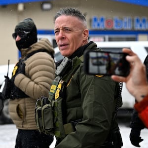 MINNEAPOLIS, MINNESOTA - JANUARY 21: A community member records U.S. Border Patrol Commander Gregory Bovino (C) as federal agents stop at a gas station on January 21, 2026 in Minneapolis, Minnesota. A reported 3,000 Department of Homeland Security federal agents have been deployed to the state, with more on the way, amid the Trump administration's major crackdown on immigration enforcement. (Photo by Stephen Maturen/Getty Images)