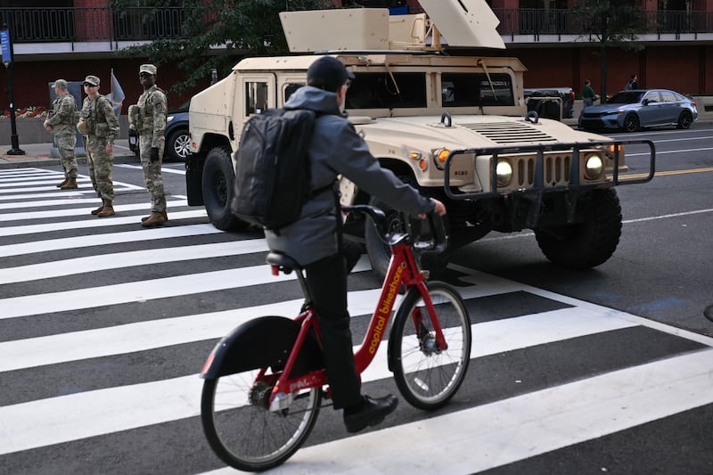 A cyclist passes members of the US National Guard in Washington, D.C. on September 24, 2026.