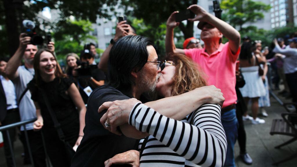 Two people kiss in celebration after Donald Trump is found guilty in New York City.