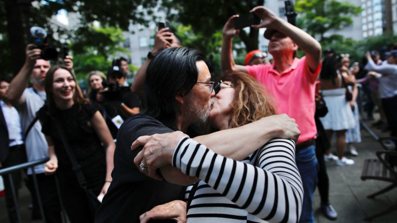Two people kiss in celebration after Donald Trump is found guilty in New York City.