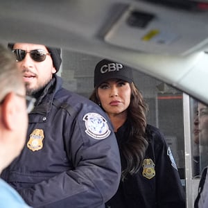 US Secretary of Homeland Security Kristi Noem (R) watches as a Customs and Border Protection officer checks people in cars as they pass through the Mariposa-Nogales Port of Entry in Nogales, Arizona, March 15, 2025.