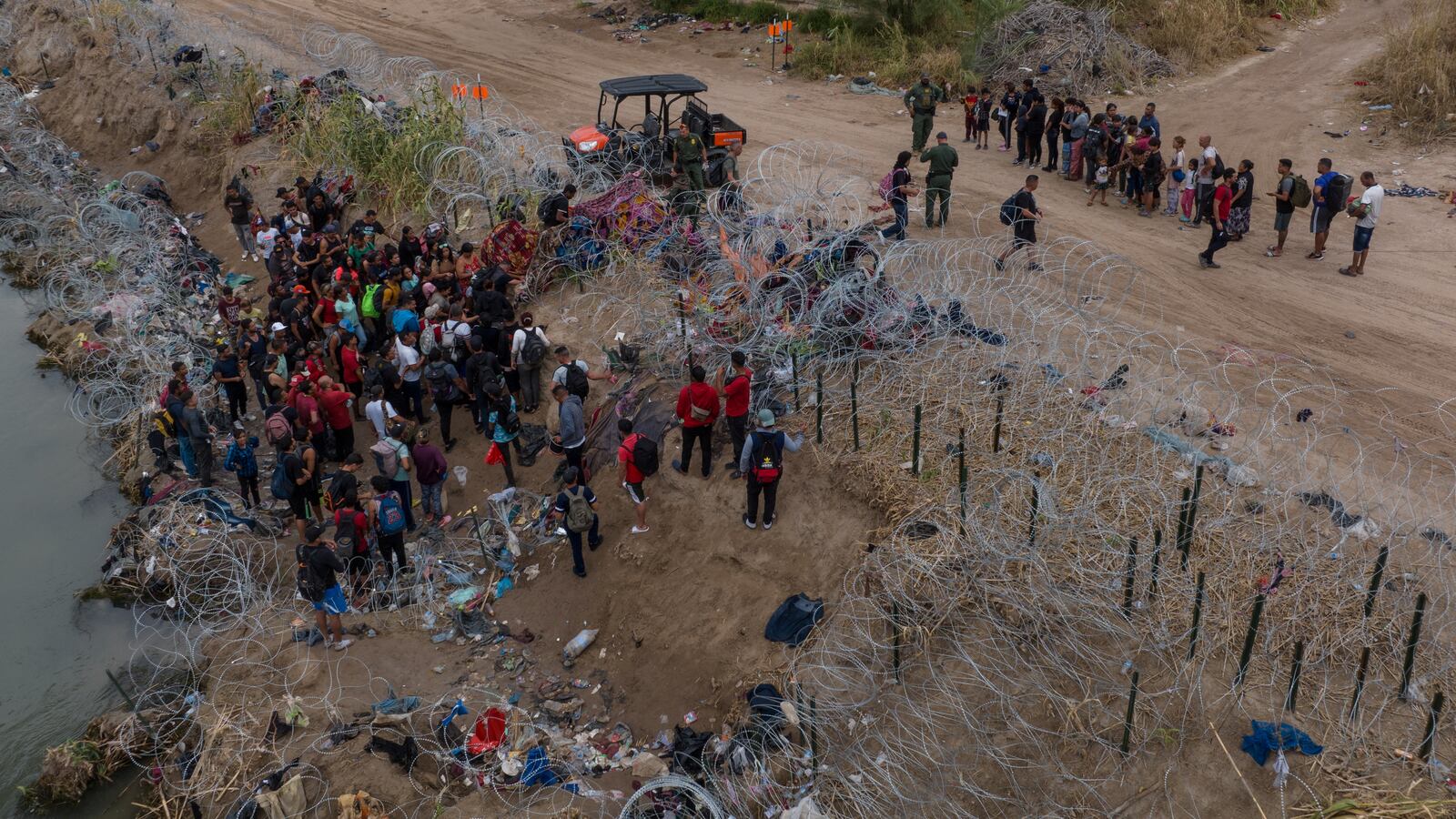 Migrants, mostly from Venezuela, surrender to authorities under the Puente Negro Ferrocarril train bridge