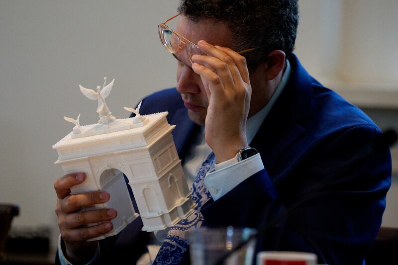 Member of the Fine Arts Commission inspects a model of President Donald Trump's proposed triumphal arch.