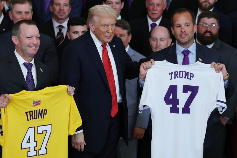 U.S. President Donald Trump poses for a photo with Brad Neffendorf (R), the head coach of the Louisiana State University (LSU) Shreveport Pilots and Jay Johnson (L), the head coach of the Louisiana State University (LSU) Tigers Head Coach arrive to an event for the baseball teams in the East Room of the White House on October 20, 2025 in Washington, DC. Trump honored the LSU Tigers for their NCAA championship and the LSU-Shreveport Pilots for their NAIA national championship and record-setting 59-0 season. (Photo by Anna Moneymaker/Getty Images)