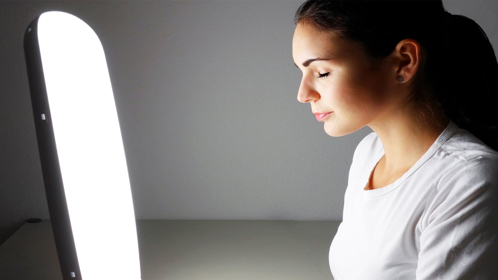 woman in front of vitamin d happy lamp sunshine sun uva uvb ray phototherapy seasonal affective disorder depression SAD winter blues