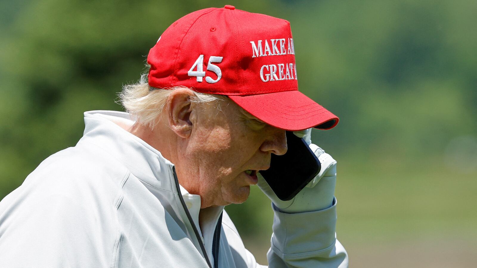 Former U.S. President Donald Trump talks on his phone between shots, as he participates in the Pro-Am tournament ahead of the LIV Golf Invitational at the Trump National Golf Club in Sterling, Virginia, U.S. May 25, 2023.