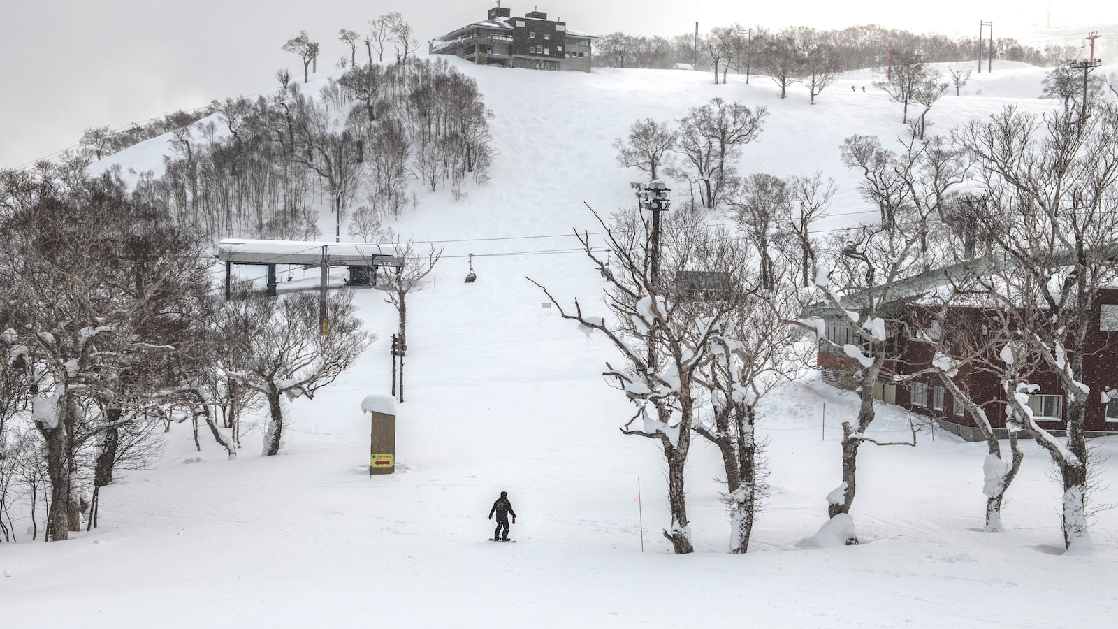 A snowboarder stands at the bottom of a slope on January 27, 2021 in Niseko, Japan.