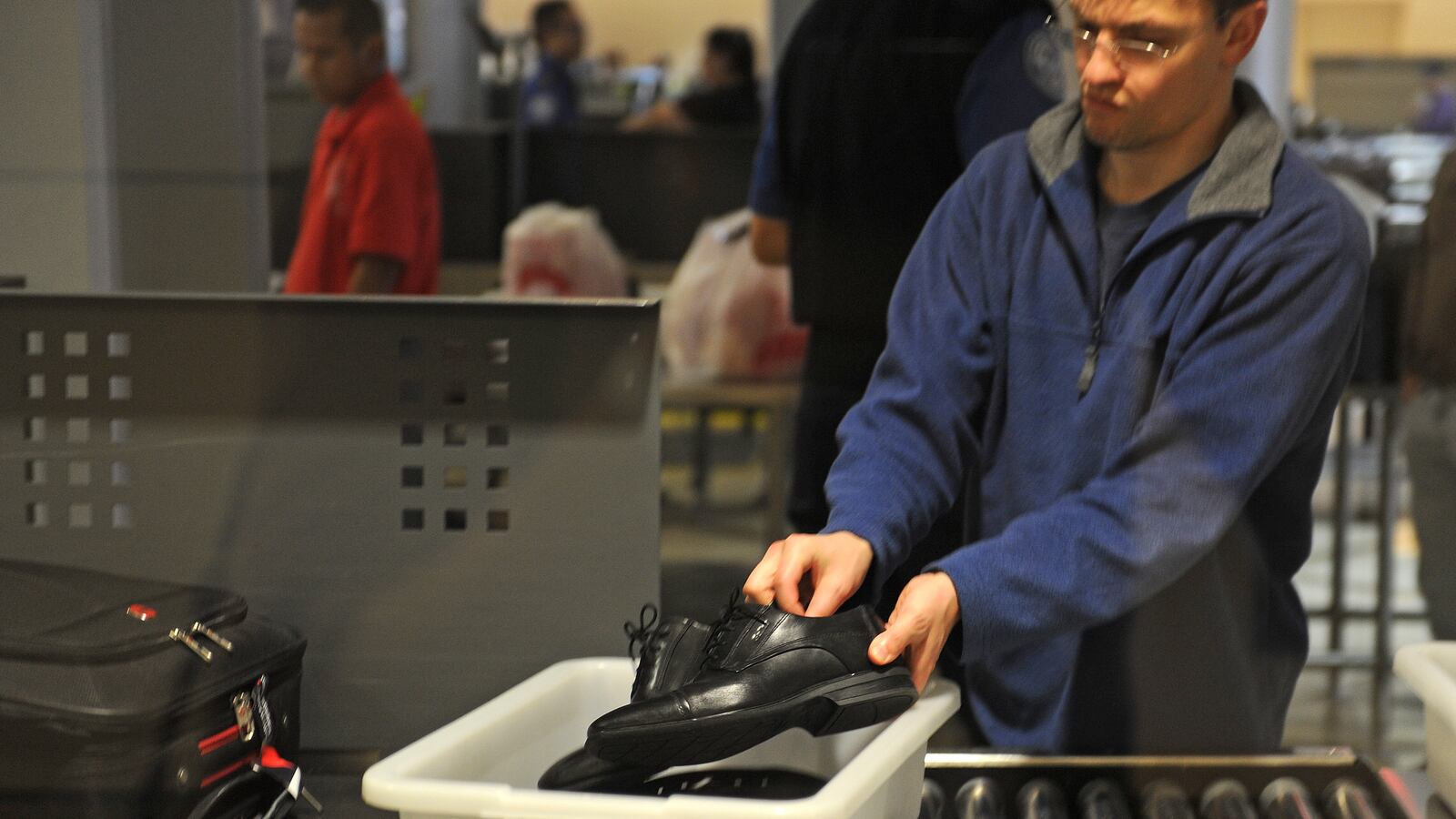 An air traveler places his shoes in a bin before passing through the Transportation Security Administration (TSA) security check at Los Angeles International Airport (LAX) on February 20, 2014 in Los Angeles, California. The TSA recently launched a PreCheck program that allows those enrolled in a trusted traveler network to enter about 100 US airports through a special security lane where they dont have to take off shoes, belts and jackets or remove laptops, liquids or gels. AFP PHOTO / ROBYN BECK (Photo credit should read ROBYN BECK/AFP via Getty Images)