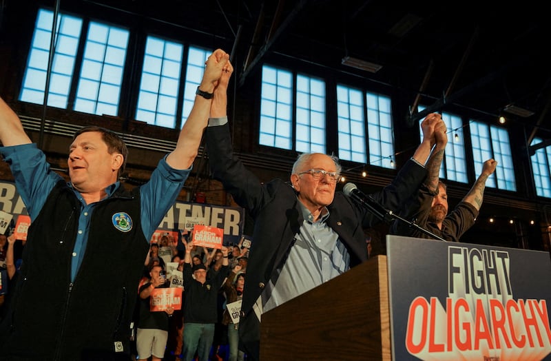 Democratic candidate for governor Troy Jackson, U.S. Senator Bernie Sanders (I-VT), and Graham Platner, Democratic candidate for U.S. Senate in Maine, raise their hands during a "Fighting Oligarchy" campaign rally in Portland, Maine, U.S., May 25, 2026.   REUTERS/Amanda Sabga