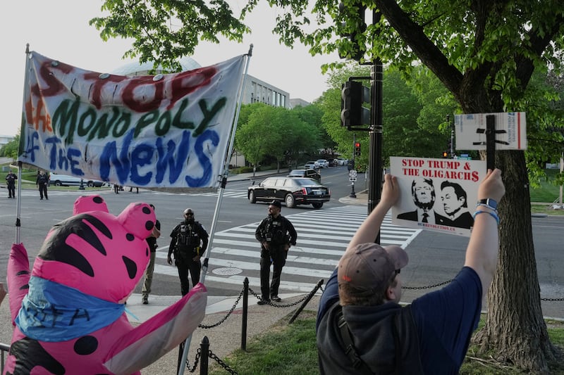 U.S. President Donald Trump's motorcade passes while demonstrators gather for a "Stop Paramount's Corruption Gala" protest outside the Donald J. Trump Institute of Peace.