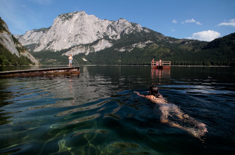 People enjoy the Altausseer See (Altaussee lake) in the alpine village of Altaussee in Austria's southern province of Styria August 23, 2012. Austria was hit by a heat wave with temperatures up to 36 degrees Celsius (97 degrees Fahrenheit) during the last week, according to Austria's national weather service agency ZAMG.    REUTERS/Herwig Prammer (AUSTRIA - Tags: SOCIETY ENVIRONMENT)