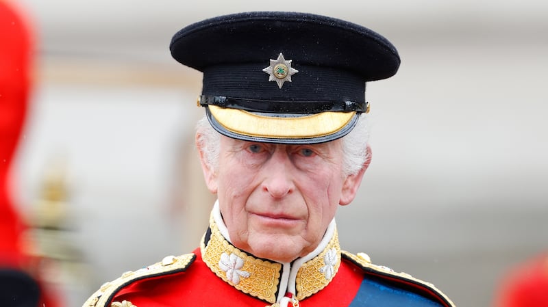 King Charles III, wearing his Irish Guards uniform, takes the salute from a dais outside Buckingham Palace after Trooping the Colour on June 15, 2024 in London, England. Trooping the Colour, also known as The King's Birthday Parade, is a military ceremony to mark the official birthday of the British Sovereign. The ceremony takes place at Horse Guards Parade followed by a flypast over Buckingham Palace and was first performed in the mid-17th century during the reign of King Charles II. The parade features all seven regiments of the Household Division with Number 9 Company, Irish Guards being the regiment this year having their Colour Trooped. (Photo by Max Mumby/Indigo/Getty Images)