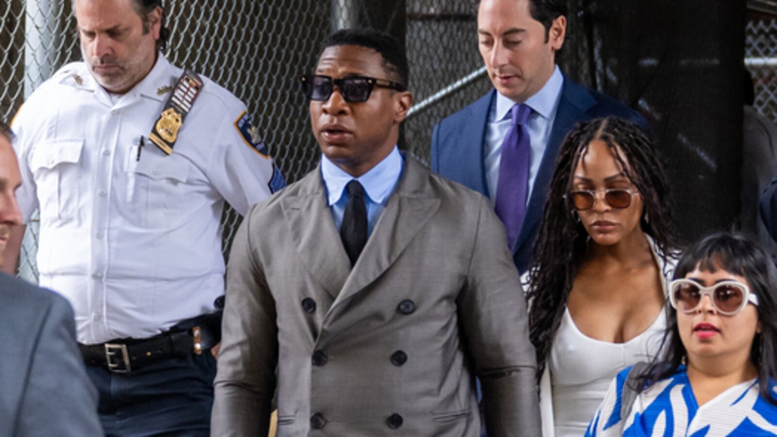 A photo of Jonathan Majors leaving court.