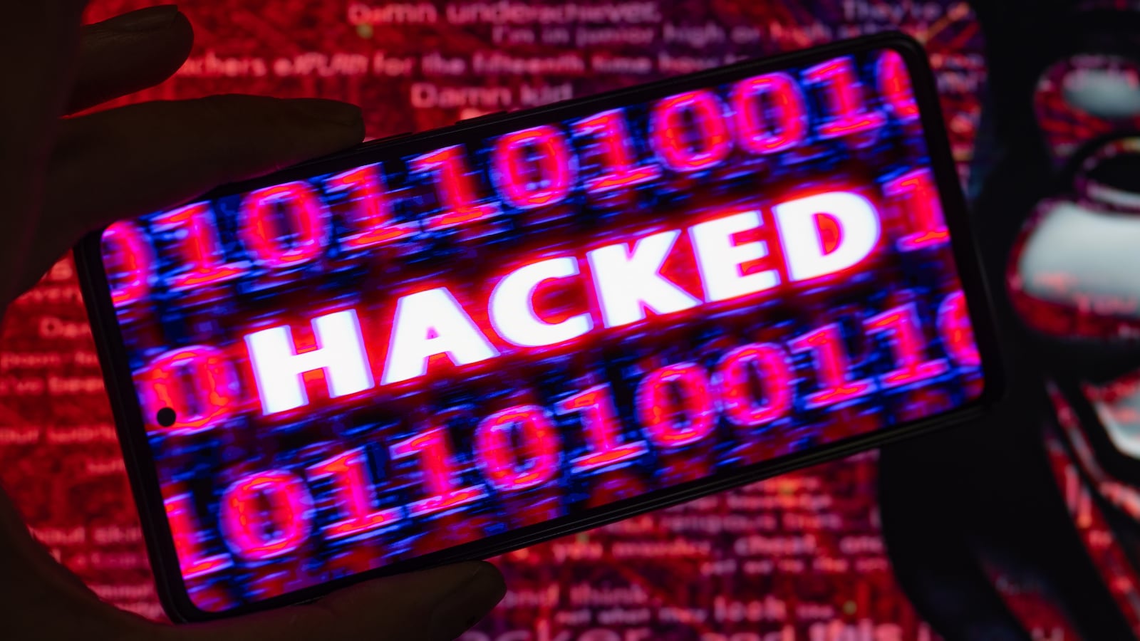 Hacked displayed on a mobile with binary code with in the background Anonymous mask. On 9 August 2023 in Brussels, Belgium. Jonathan Raa / Nurphoto (Photo by Jonathan Raa/NurPhoto via Getty Images)