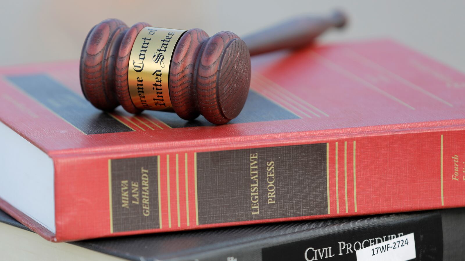 A gavel is seen on legal books.