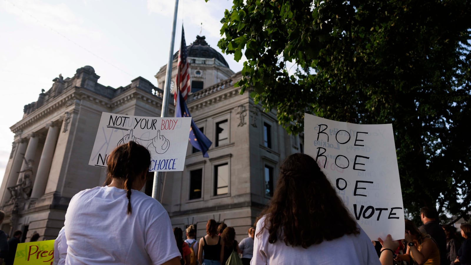 Abortion rights activists holds placards at the Monroe County Courthouse during a protest vigil a few hours before Indiana’s near total abortion ban goes into effect in Bloomington. Now, Indiana’s Supreme Court has upheld the ban.