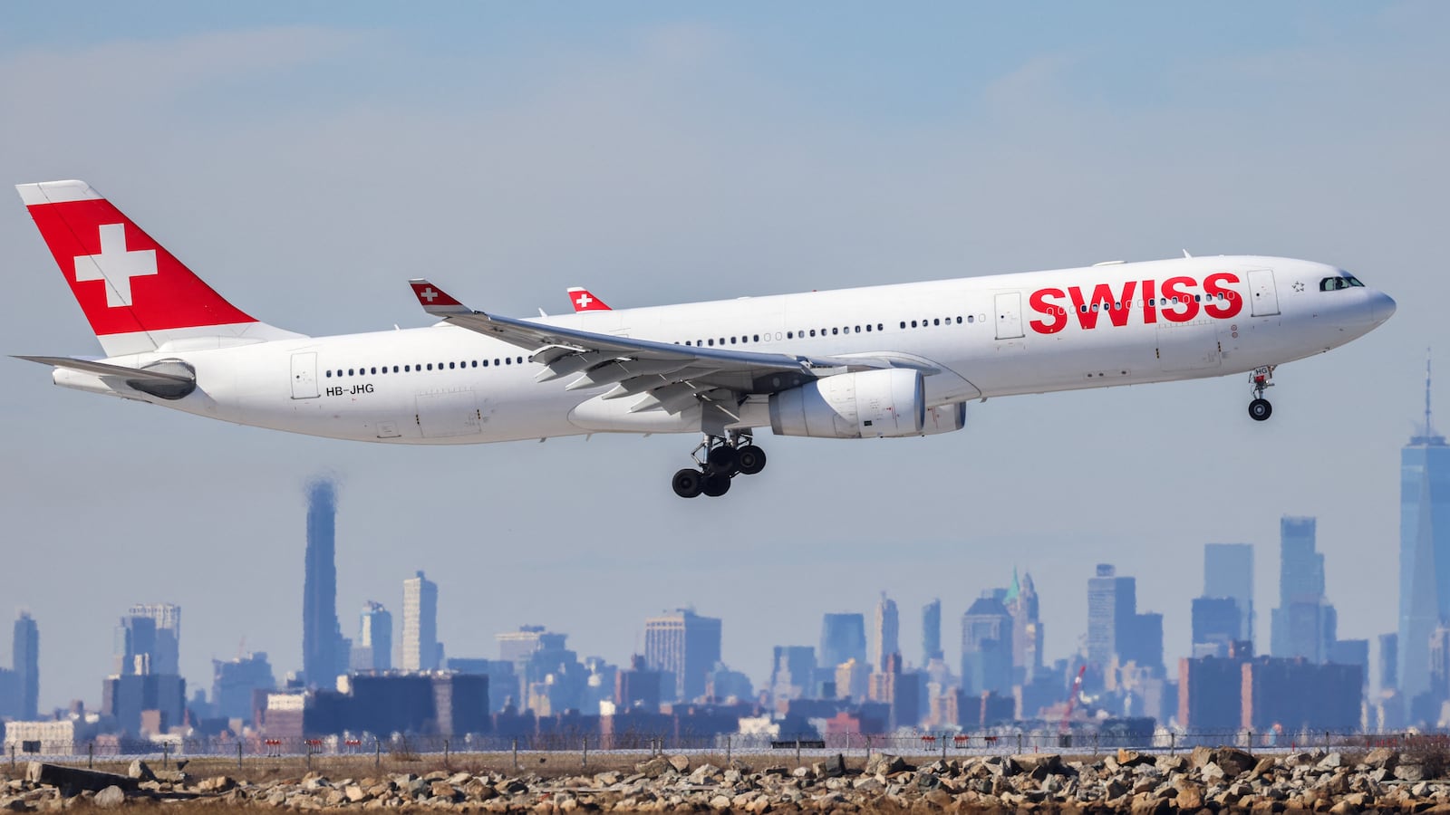 An Airbus A330 passenger aircraft of Swiss airlines arrives from Zurich at JFK International Airport in New York as the Manhattan skyline looms in the background on February 7, 2024. (Photo by Charly TRIBALLEAU / AFP via Getty Images)