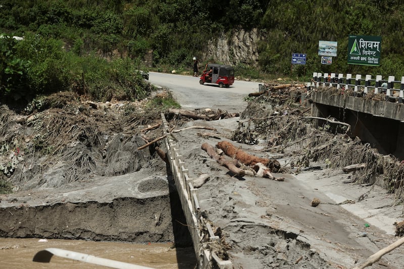 An auto rickshaw drives past a broken bridge following a flash flood in Galchhi, Nepal, August 27, 2026. REUTERS/Francis Mascarenhas