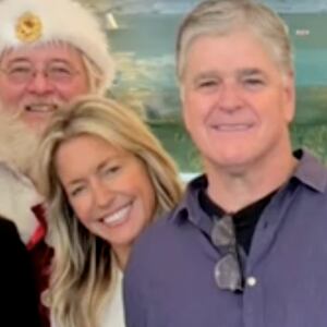 Ainsley Earhardt and Sean Hannity are seen posing together along with a staffer and a man dressed as Santa in a photo shared during the January 6 broadcast of Fox & Friends.