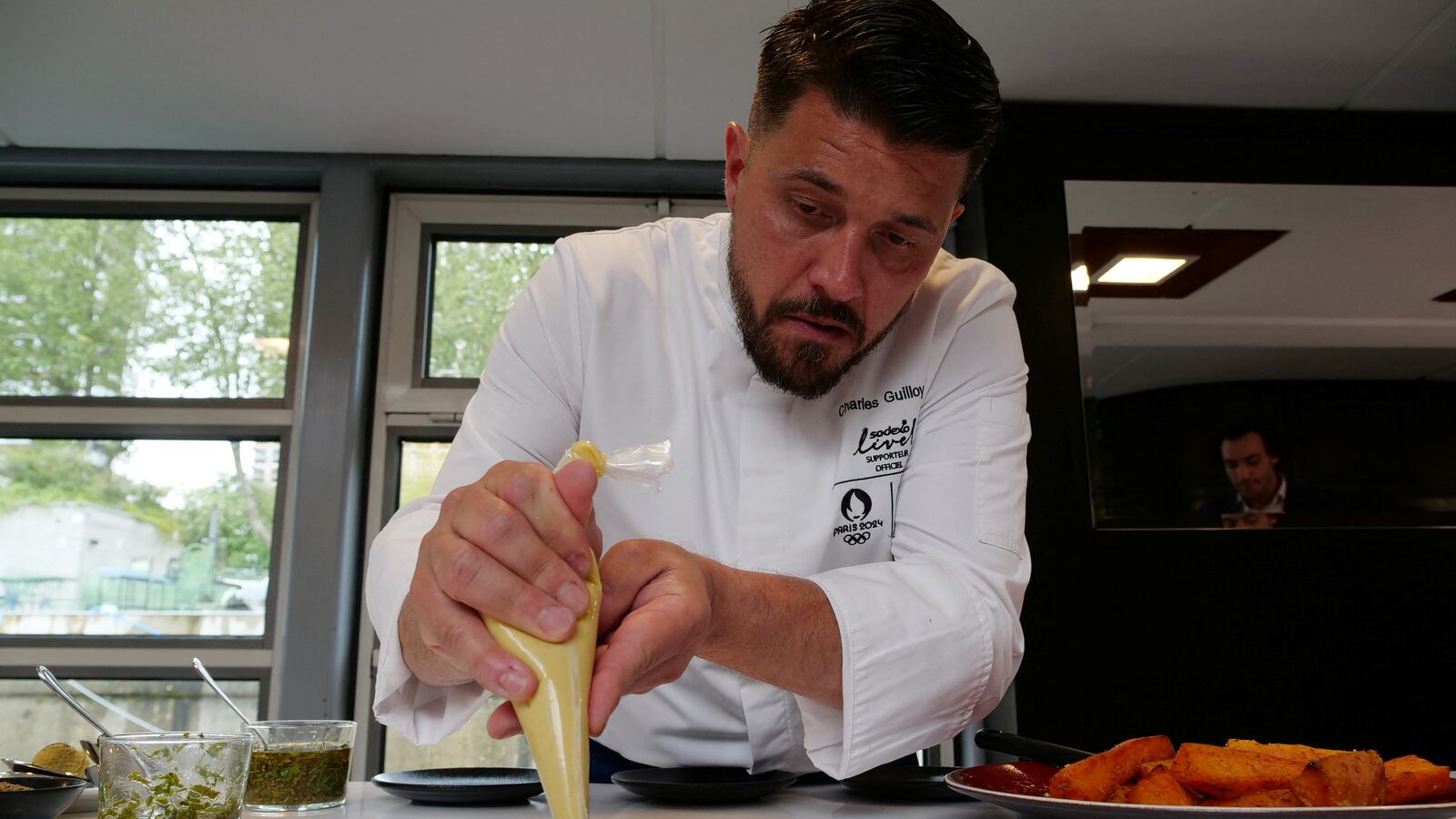 Chef Charles Guilloy showing some of the dishes on offer at the Olympic village