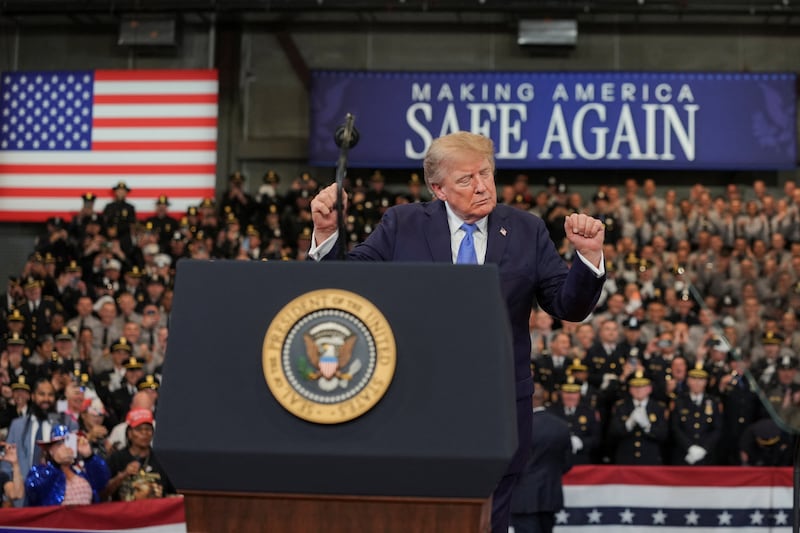 U.S. President Donald Trump dances on stage during an event at David S. Mack Center for Training and Intelligence in Garden City, New York, U.S., August 14, 2026. REUTERS/Ken Cedeno