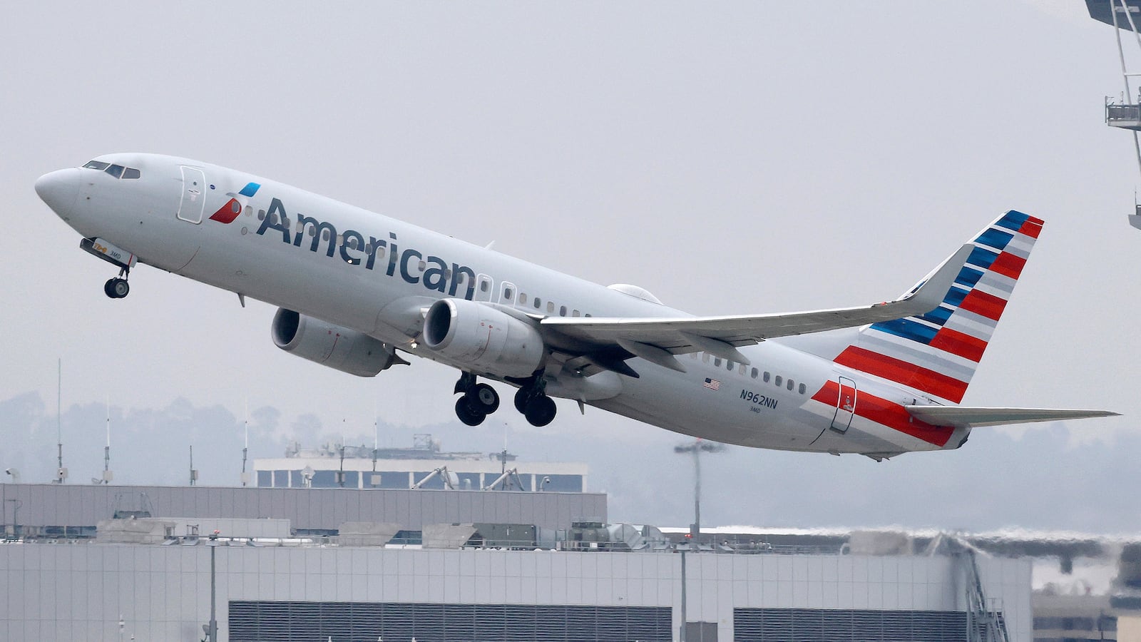 LOS ANGELES, CALIFORNIA - NOVEMBER 12: An American Airlines plane takes off near the air traffic control tower at Los Angeles International Airport (LAX) on November 12, 2025 in Los Angeles, California. The FAA (Federal Aviation Administration) has reduced flights by 10 percent in 40 major airports around the country, including LAX, with airlines warning that flight disruptions could continue even after the end of the federal government shutdown as the Thanksgiving holiday approaches. (Photo by Mario Tama/Getty Images)