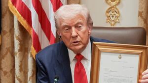 U.S. President Donald Trump holds a letter from Argentina’s President Javier Milei stating that Milei nominates Trump for the Nobel Peace Prize, during lunch with Milei in the Cabinet Room at the White House in Washington, D.C., U.S., October 14, 2025. REUTERS/Jonathan Ernst REFILE - QUALITY REPEAT