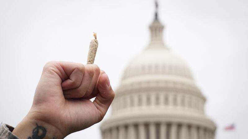 A pro-cannabis activist holds up a marijuana cigarette.