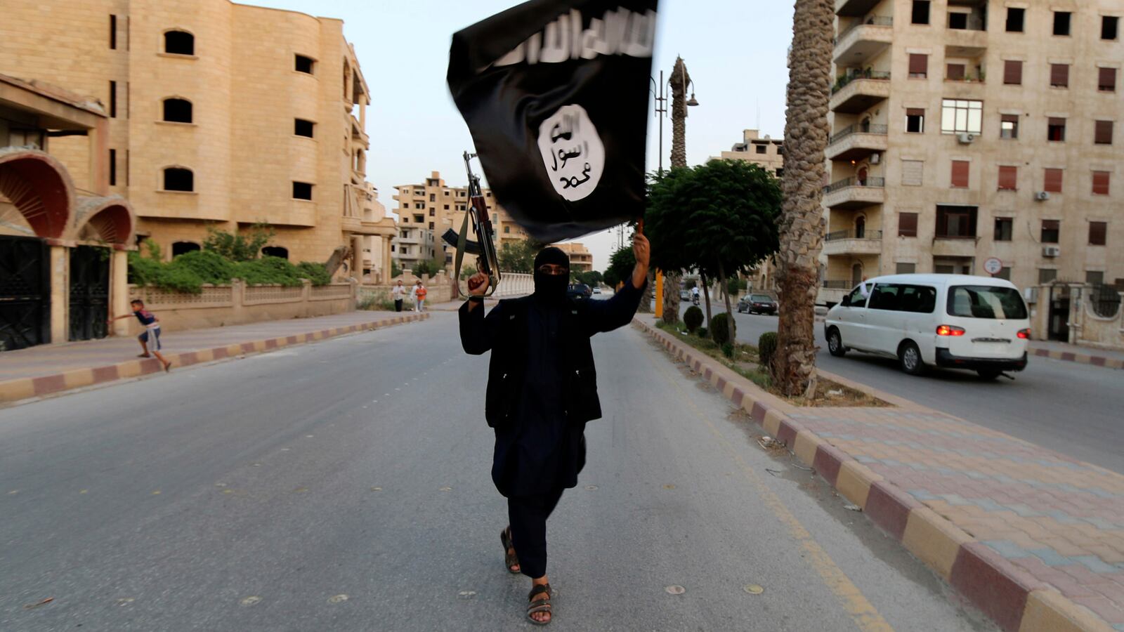 An ISIS member waves an ISIS flag in Raqqa, Syria, June 29, 2014.