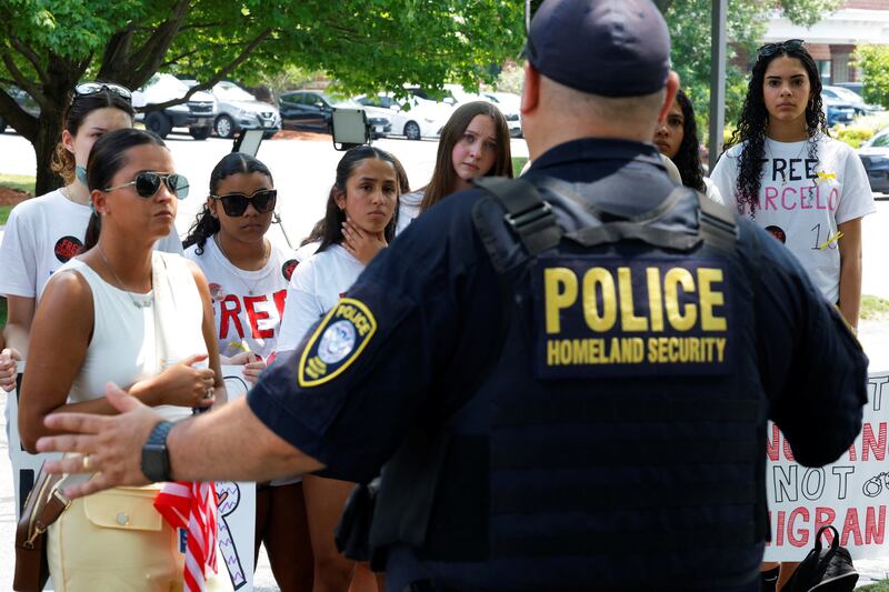 A Homeland Security officer speaks to people outside an Immigration court hearing.