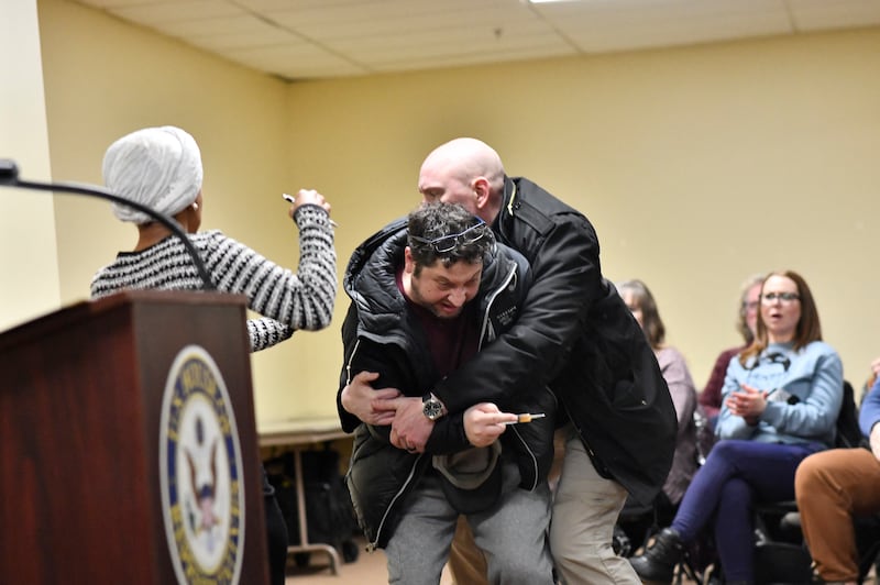 A man is tackled after spraying an unknown substance at US Representative Ilhan Omar (D-MN) (L) during a town hall she was hosting in Minneapolis, Minnesota, on January 27, 2026. (Photo by Octavio JONES / AFP via Getty Images)