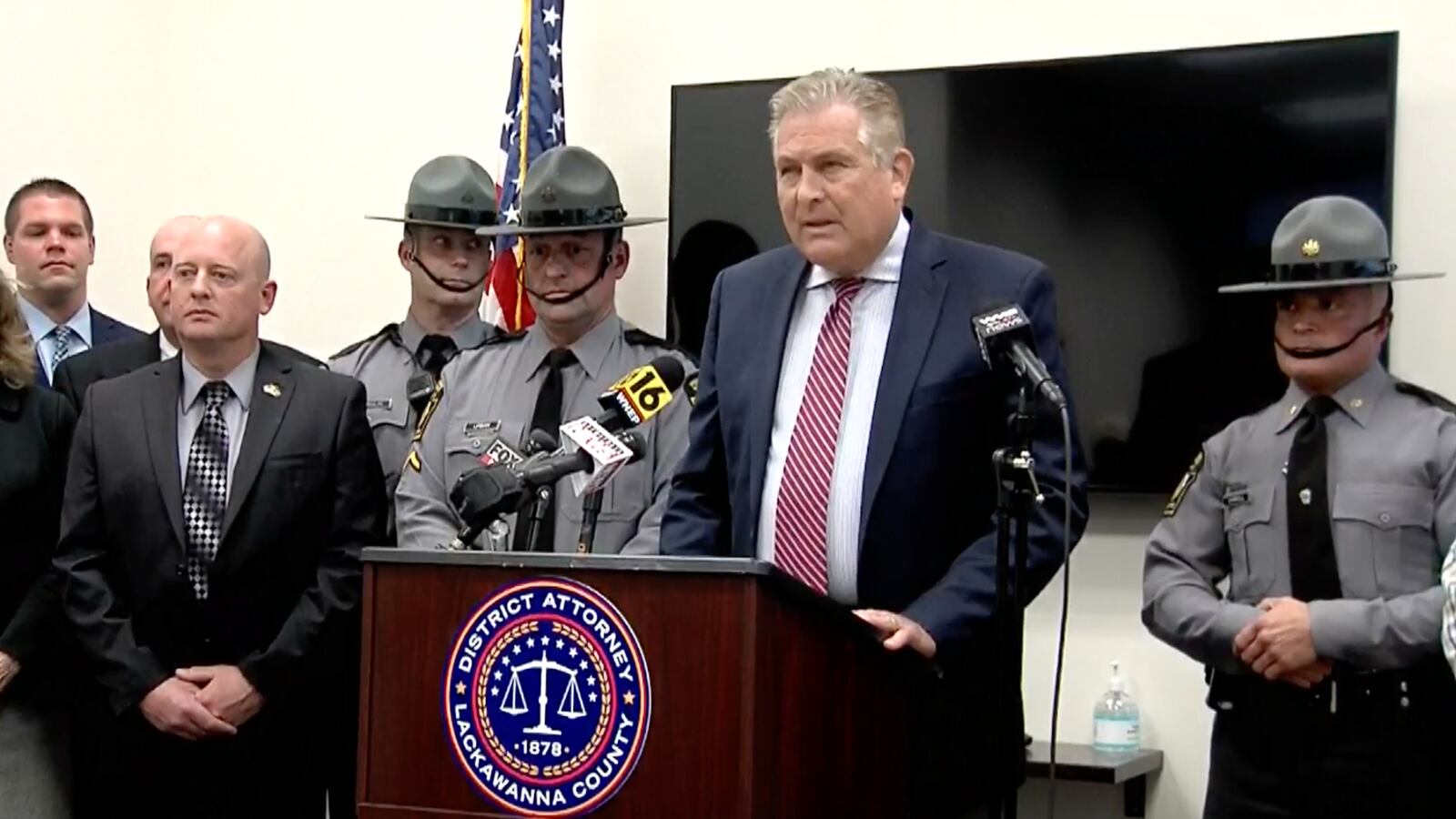 The Lackawanna County District Attorney speaks at a podium at a press conference.
