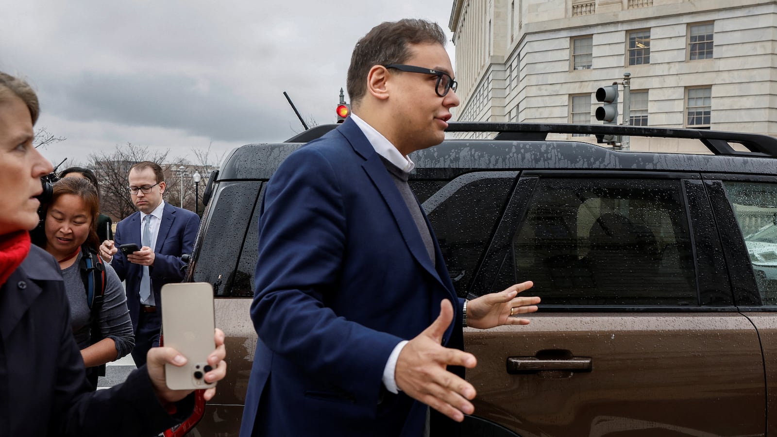 George Santos followed by reporters.