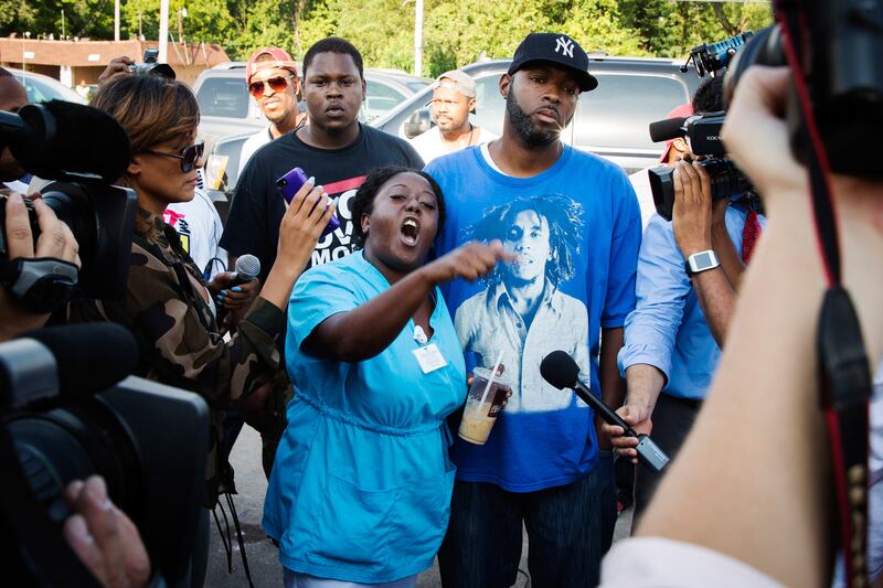 articles/2014/08/15/uneasy-peace-in-ferguson-in-danger-after-slain-brown-named-as-suspect-in-robbery/140815-glaweferguson2-embed_xeuxy5