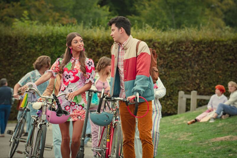 Mimi Keene as Ruby and Asa Butterfield as Otis in Sex Education  walking bikes