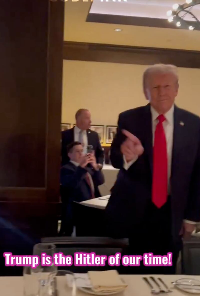 Trump gestures for the protesters to leave Joe's restaurant.
