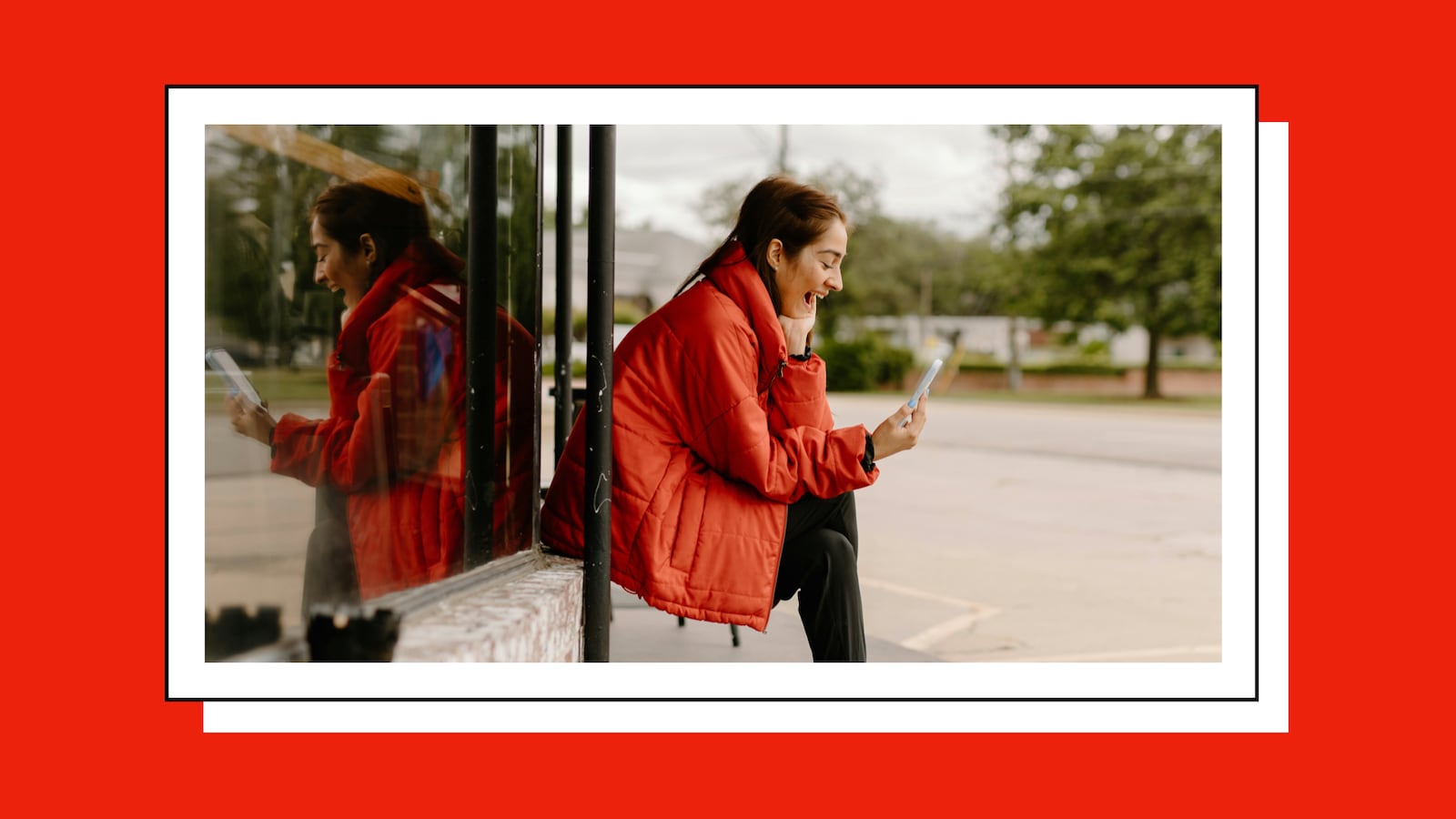 Woman laughing while looking at her phone.